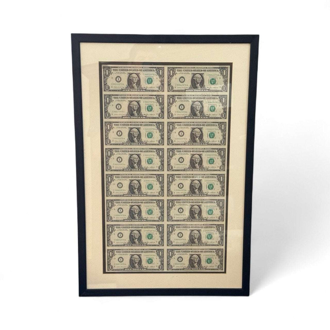 Series 1985 uncut sheet of 16 $1 bills with consecutive serials in a black wood frame display