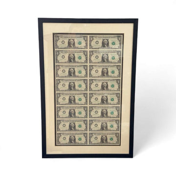 Series 1985 uncut sheet of 16 $1 bills with consecutive serials in a black wood frame display