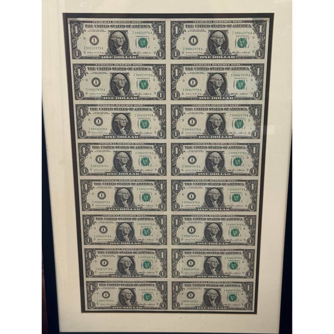 Series 1985 uncut sheet of 16 one dollar bills in a wood framed display with consecutive serials