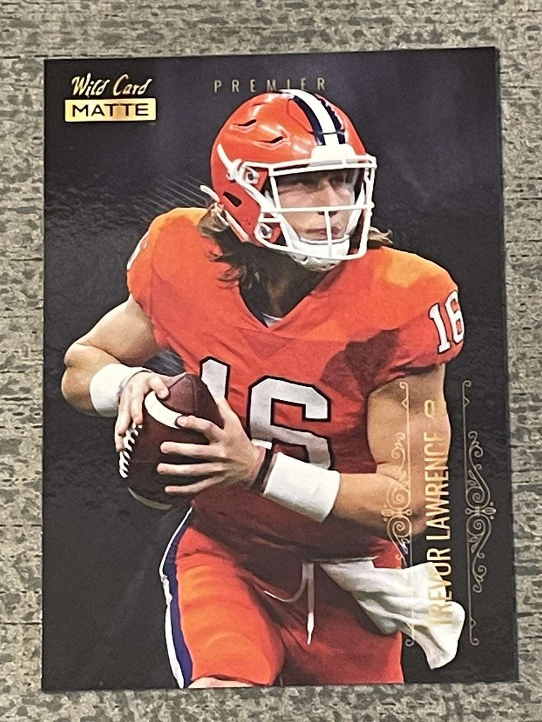 2021 Wild Card Matte Gold Trevor Lawrence rookie card in Clemson uniform holding football
